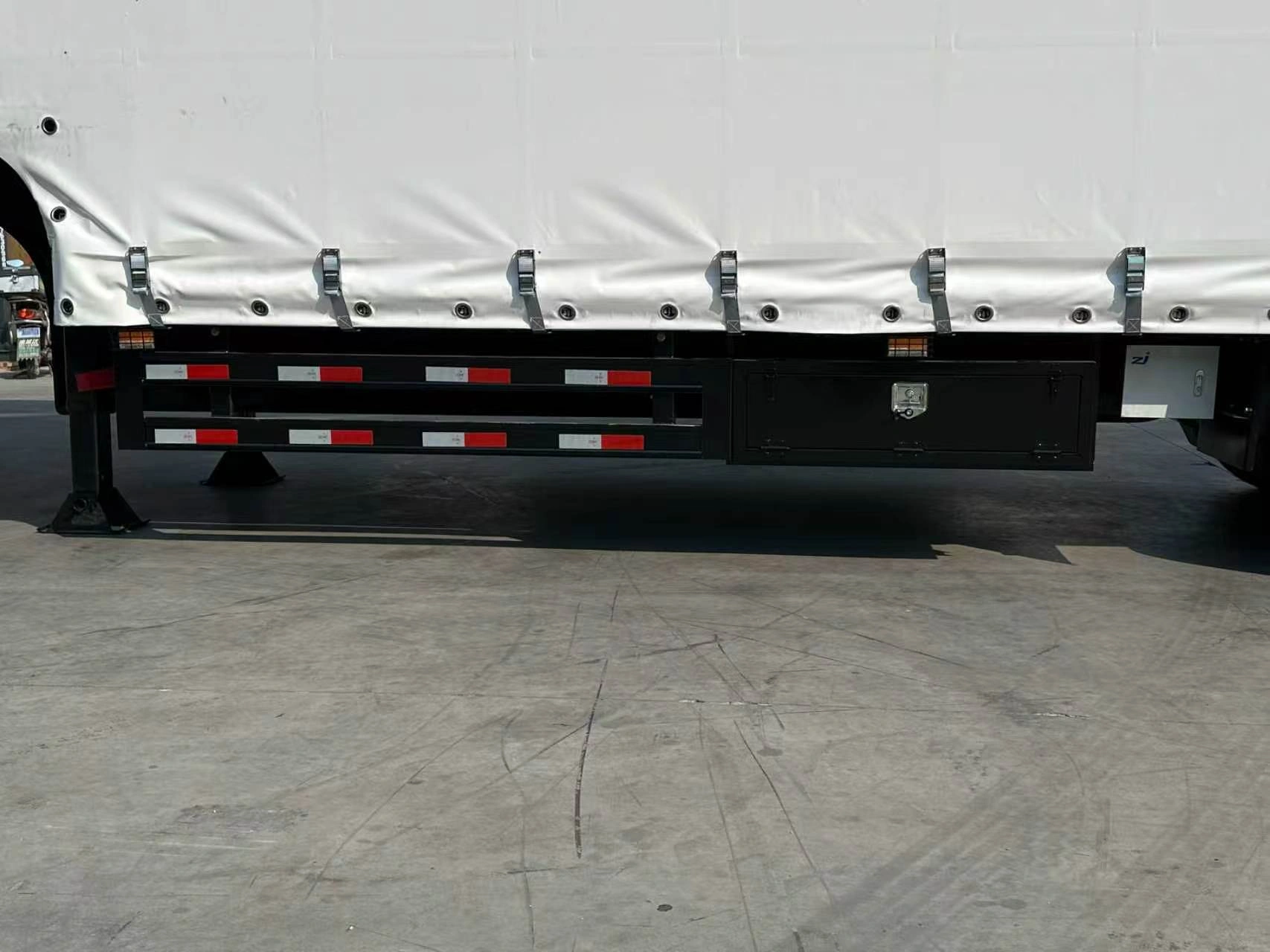 Lower curtain buckles above the side guard and toolbox on the 5 axle curtain side trailer